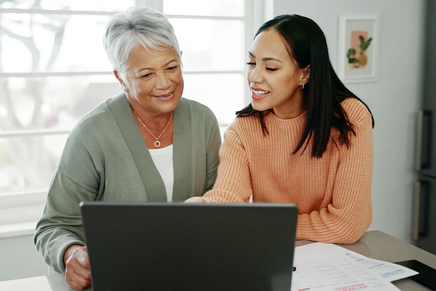 An older and younger woman reviewing documents together