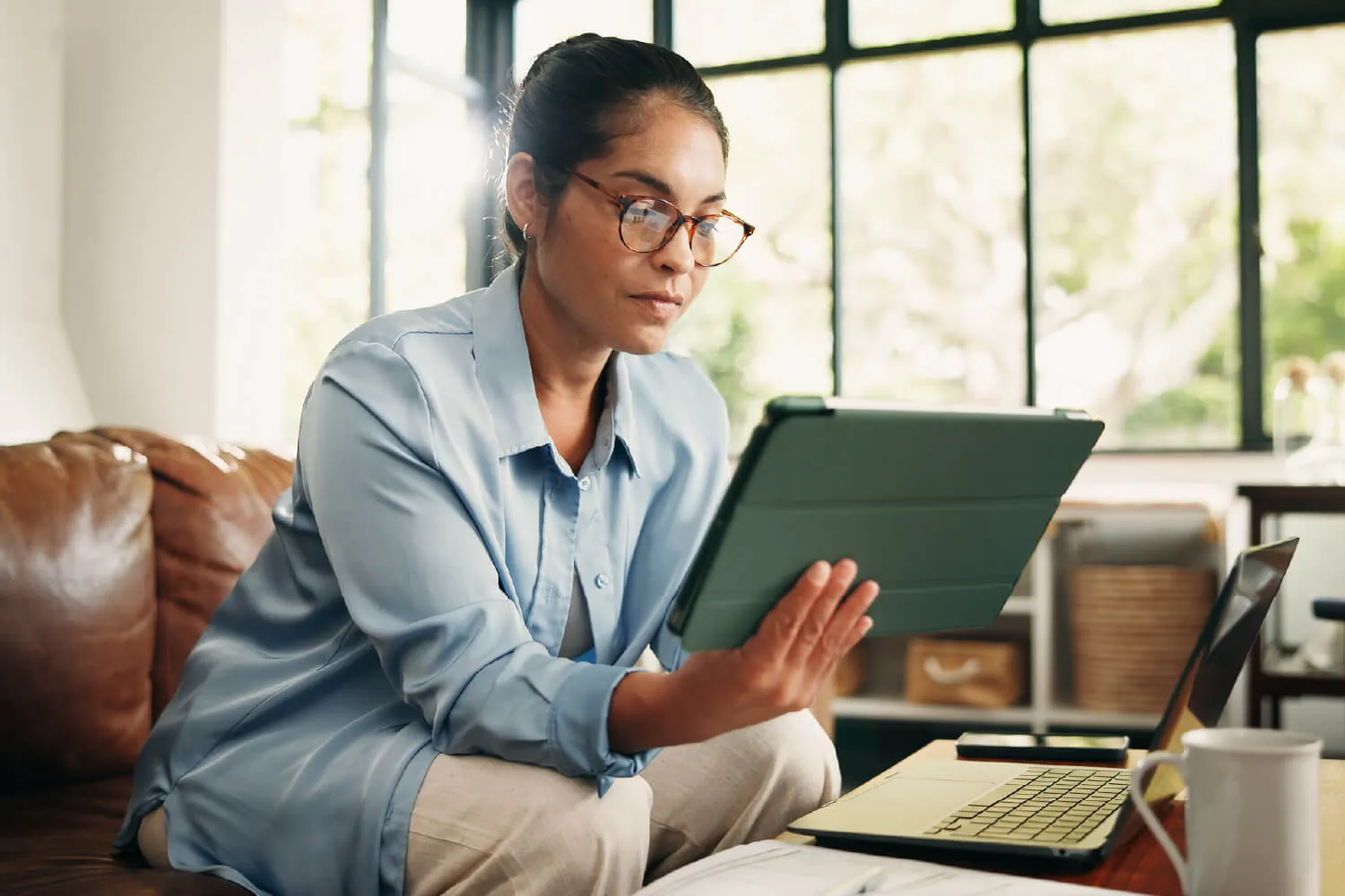 A woman reviewing documents on a tablet.