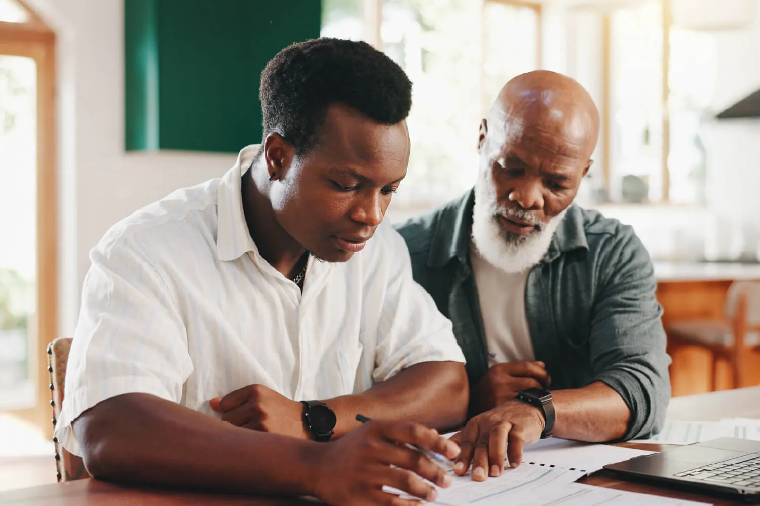 Two men sitting at a table and reviewing a document