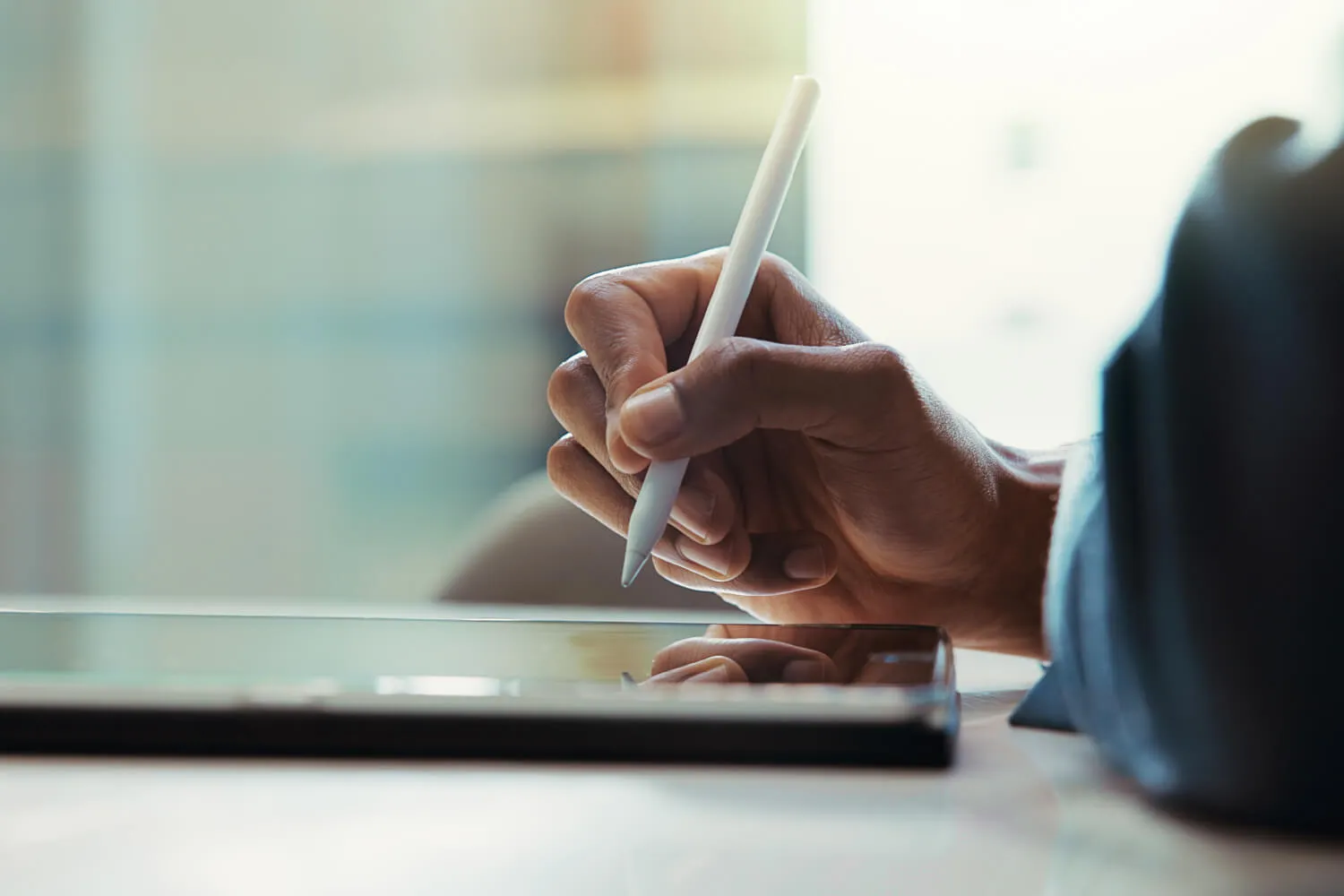 Someone signing their signature on a tablet.