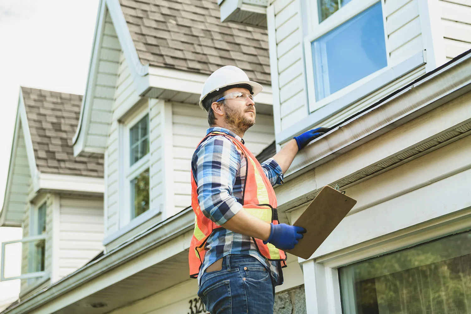 A contractor evaluating a home's gutter
