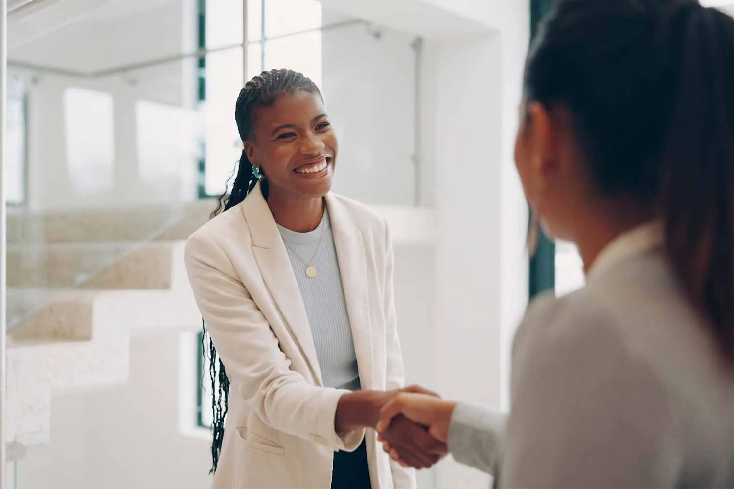 Two women shaking hands during a business meeting