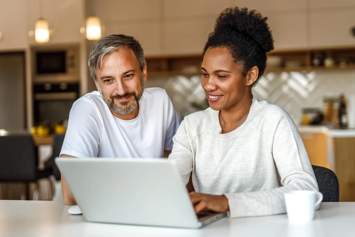 Two people looking at a computer, researching DIY will costs.