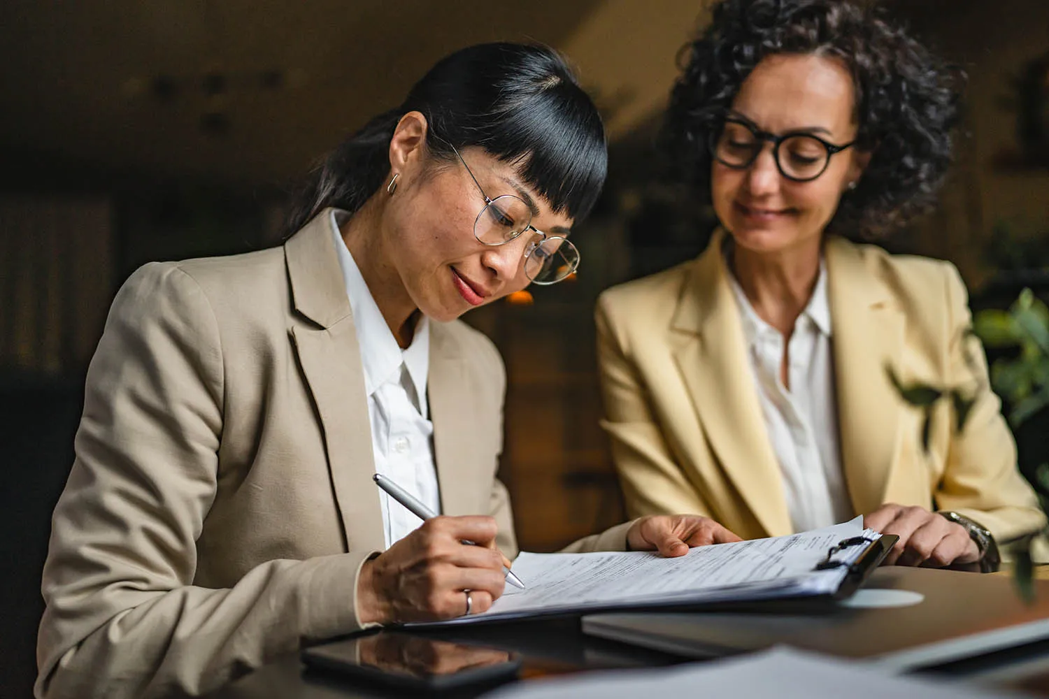 Two businesswomen signing an agreement