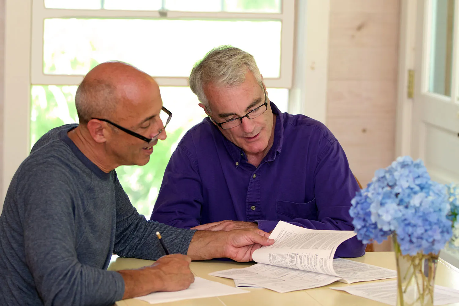 Two older adults look a a contract together.