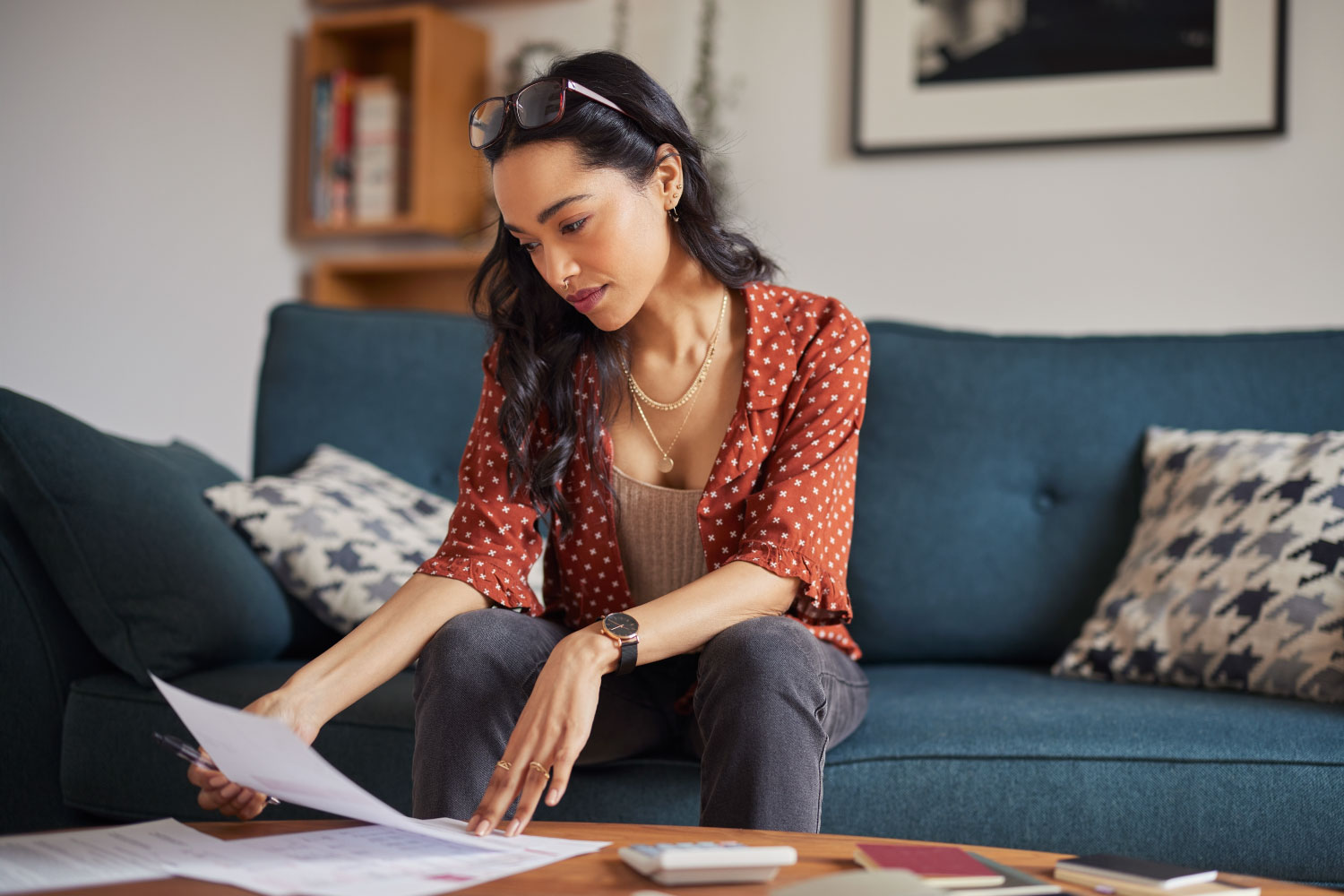 Woman looking at bills wondering how she is going to repair her credit
