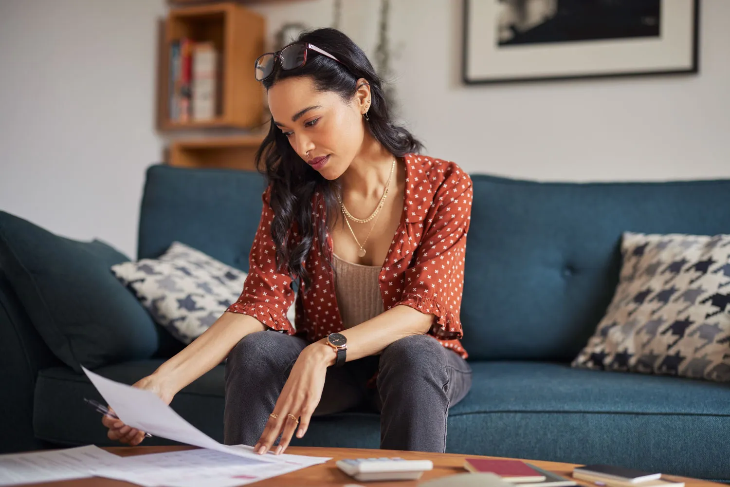 Woman looking at bills wondering how she is going to repair her credit