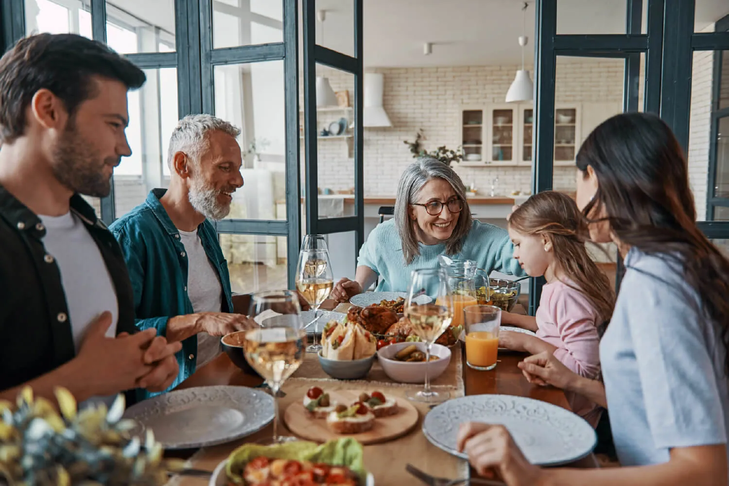 A multi-generational family sitting around a dinner table, enjoying a meal together