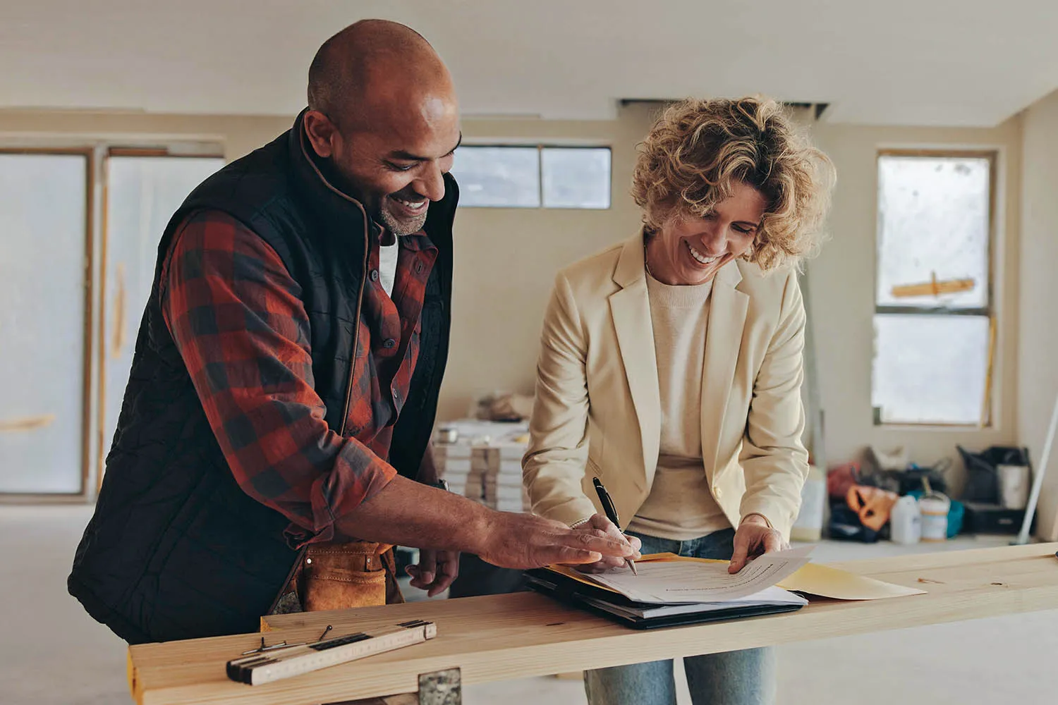 Two people standing in a newly-built house, planning the interior.