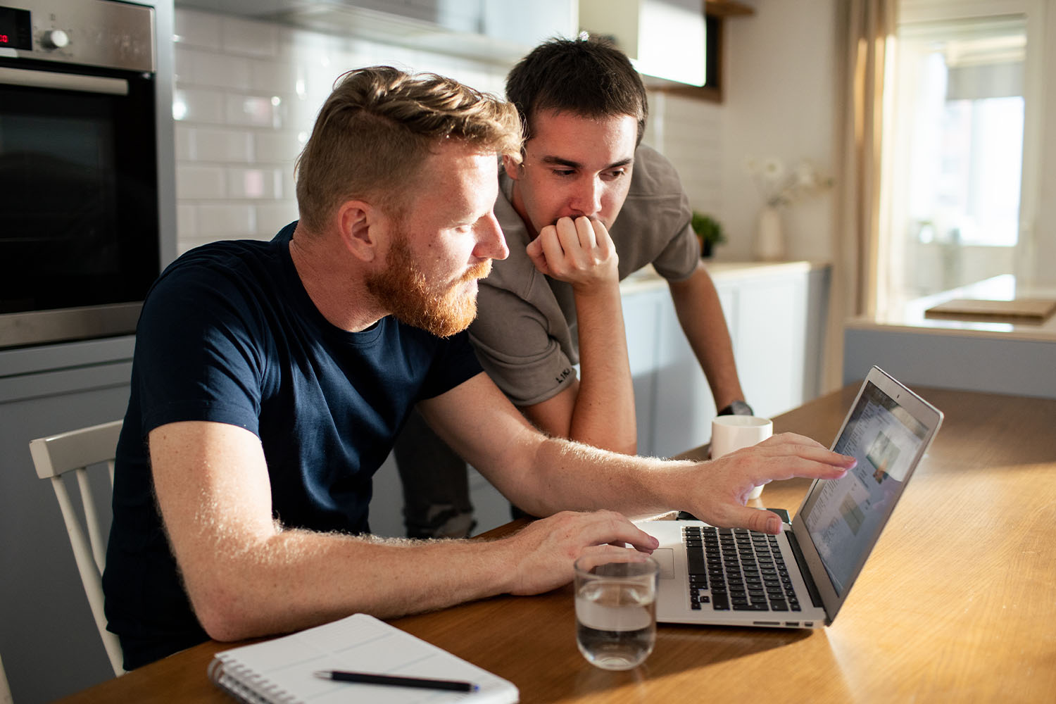 A couple looks at a laptop together in deep concentration