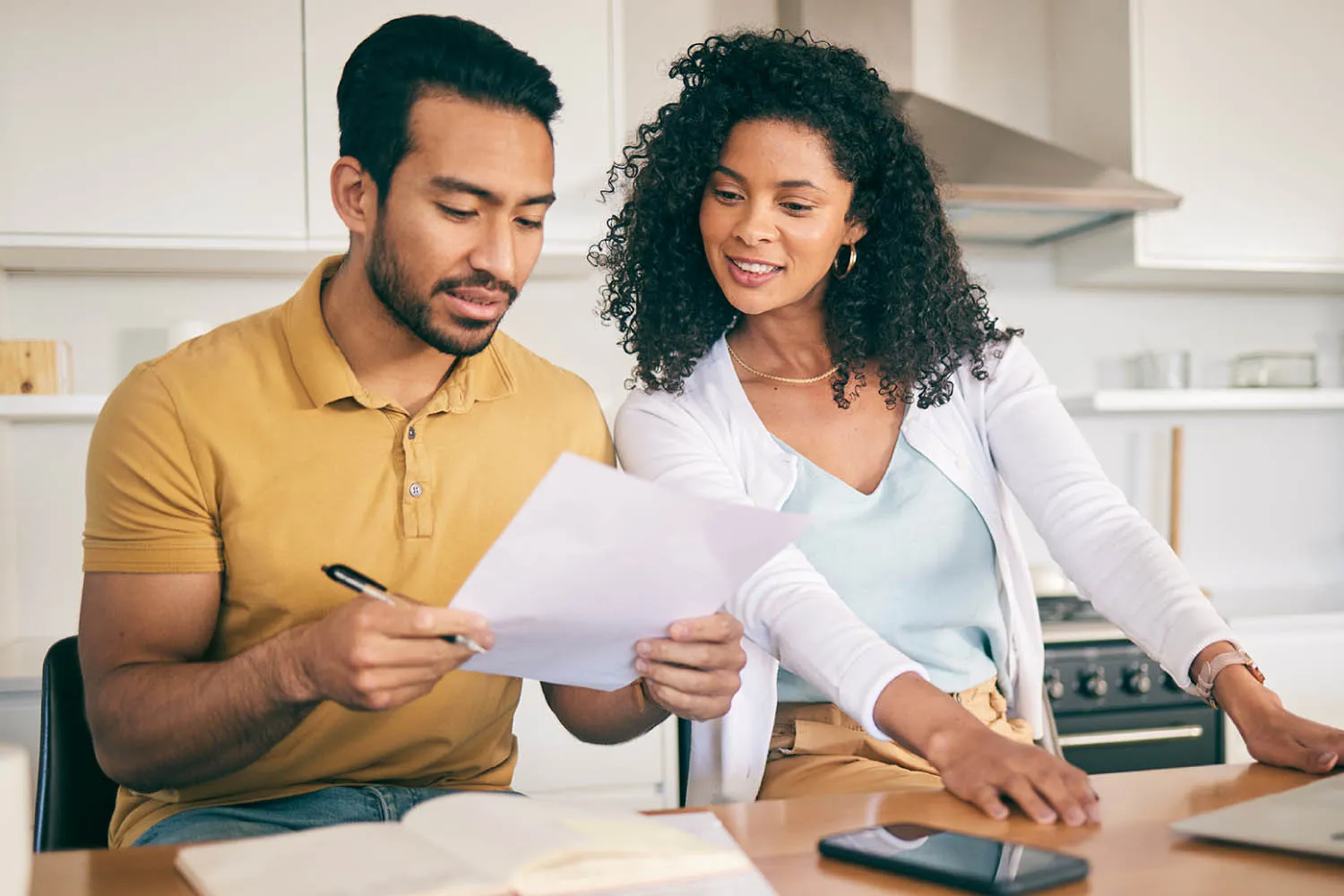 Engaged couple reviewing wedding insurance and vendor contract paperwork together