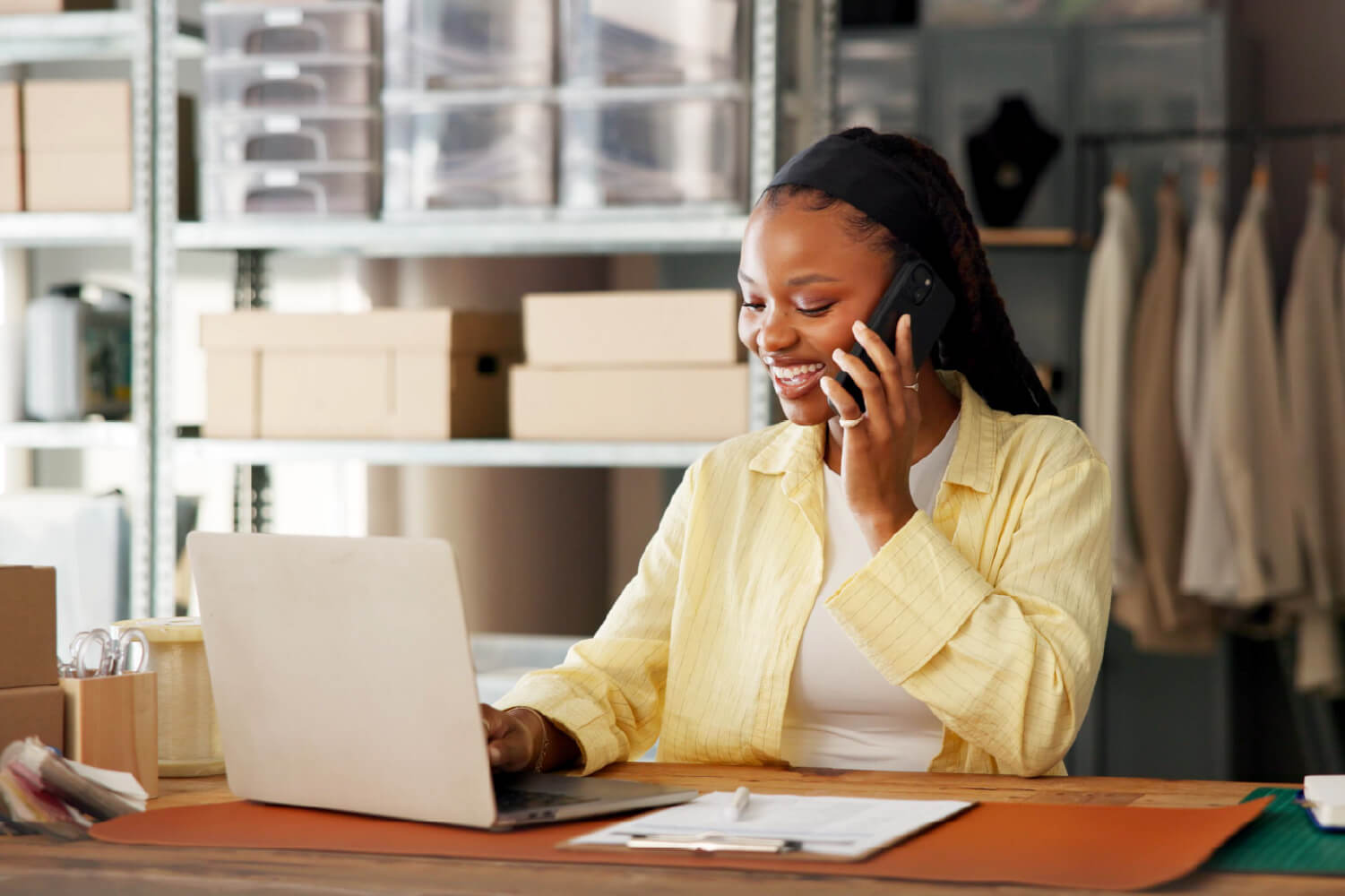 Business owner looking at a laptop while talking on a cell phone