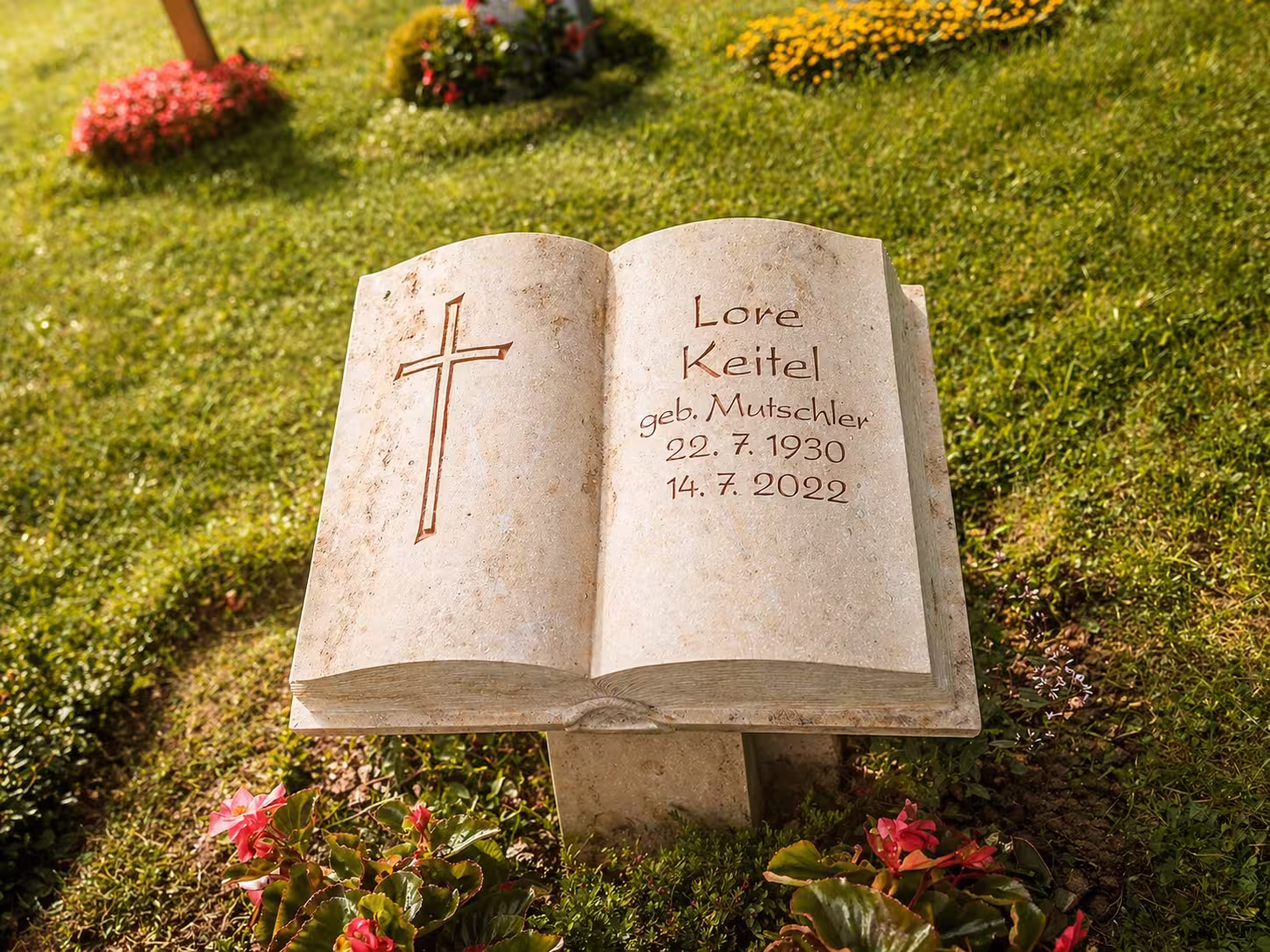 Grabstein als Bibel, mit einem Kreuz auf den Seiten und den persönlichen Daten. Hergestellt von Hermann Naturstein.