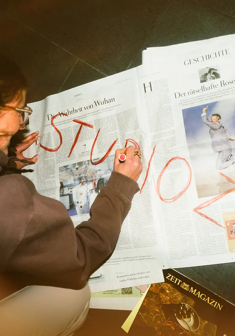 Person schreibt StudioZX auf Zeitung