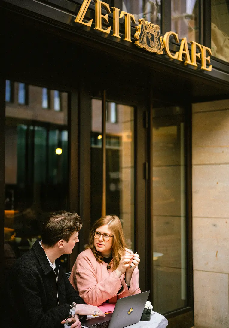 2 Personen sitzend vor dem Zeit Cafe