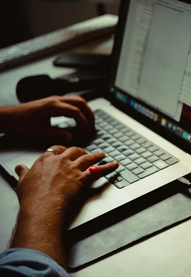 eine Person tippt auf einem Laptop