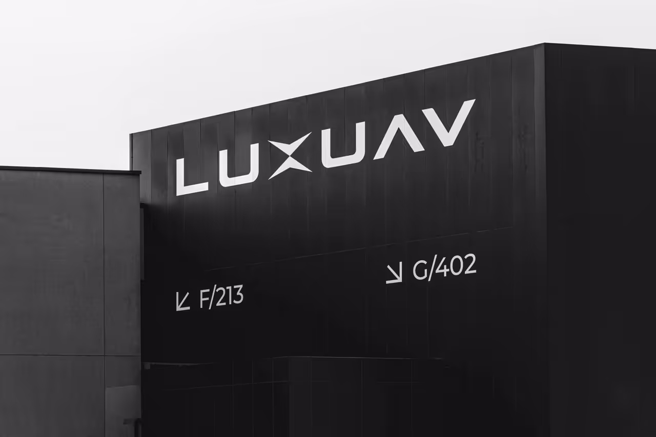 Black building facade with white LUXUAV logo and directional signs for F/213 and G/402 doors.