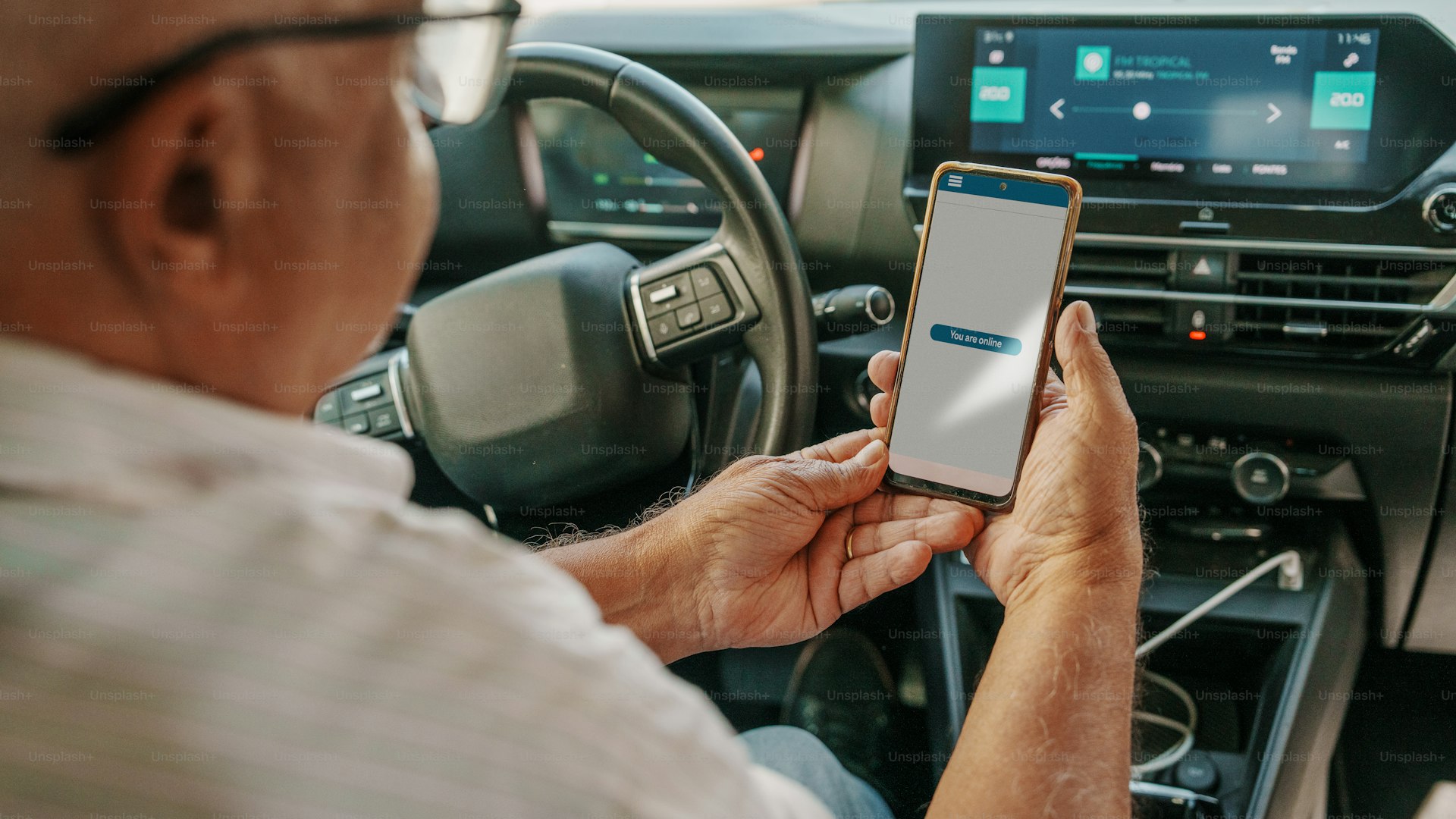Man using smartphone in car dashboard