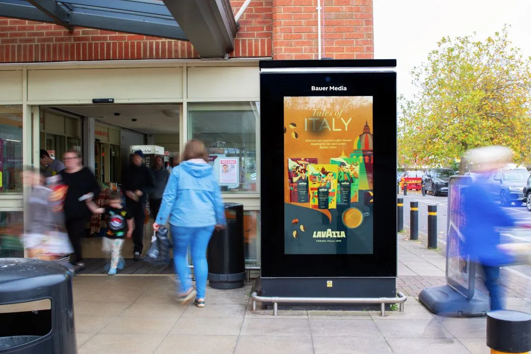 Advertising screen promoting Lavazza coffee at supermarket store entrance