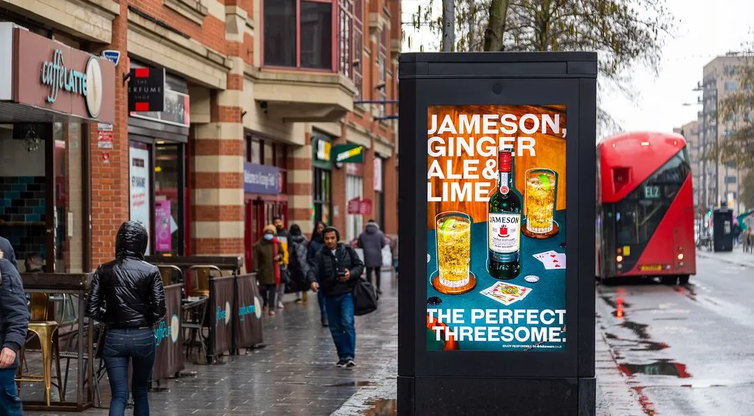 Whiskey advert on a digital poster on a high street in the rain