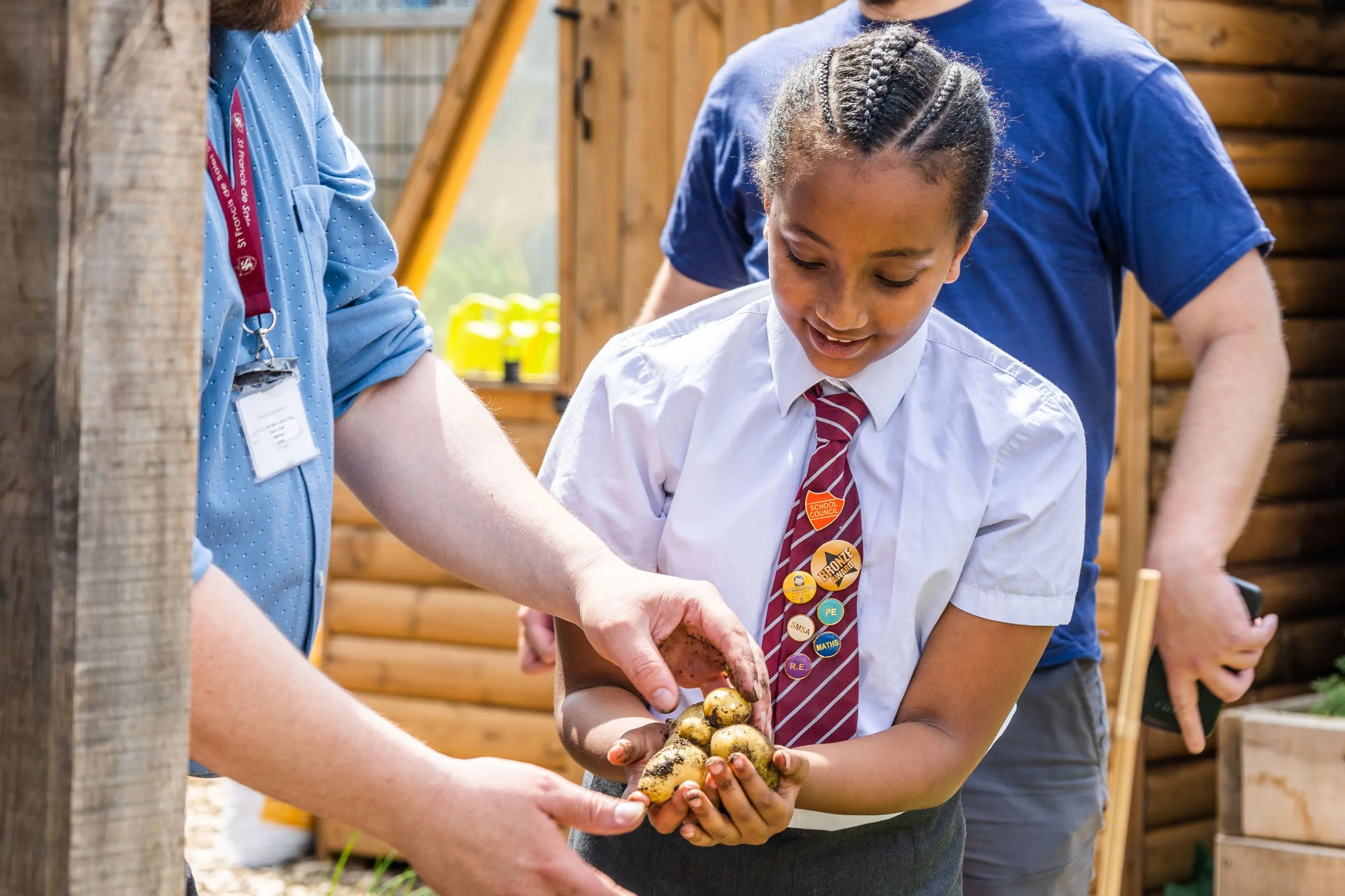 A school child harvesting potatoes in an Edible Playground funded by Bauer Media Outdoor