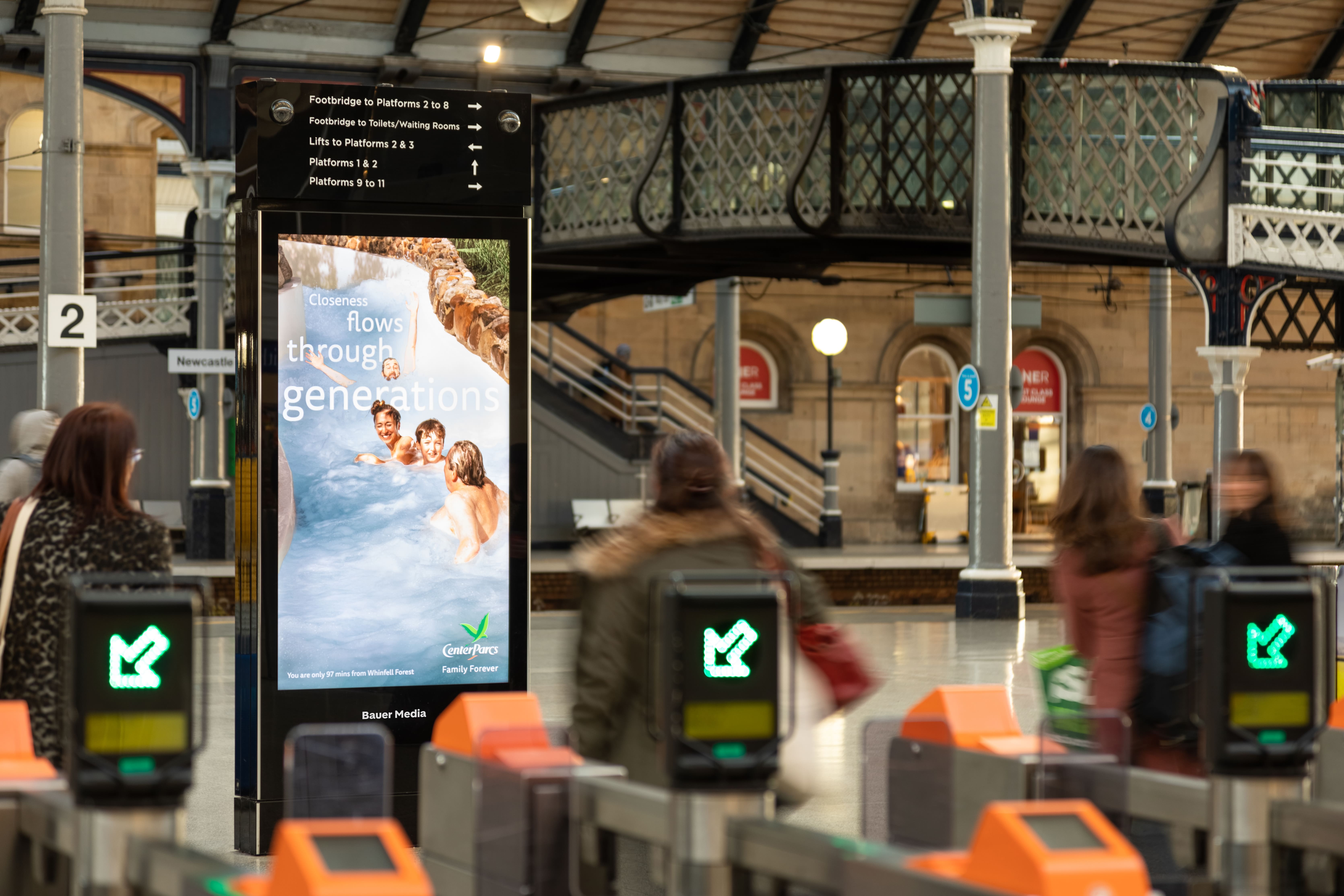 CentreParcs ad within a train station with people entering