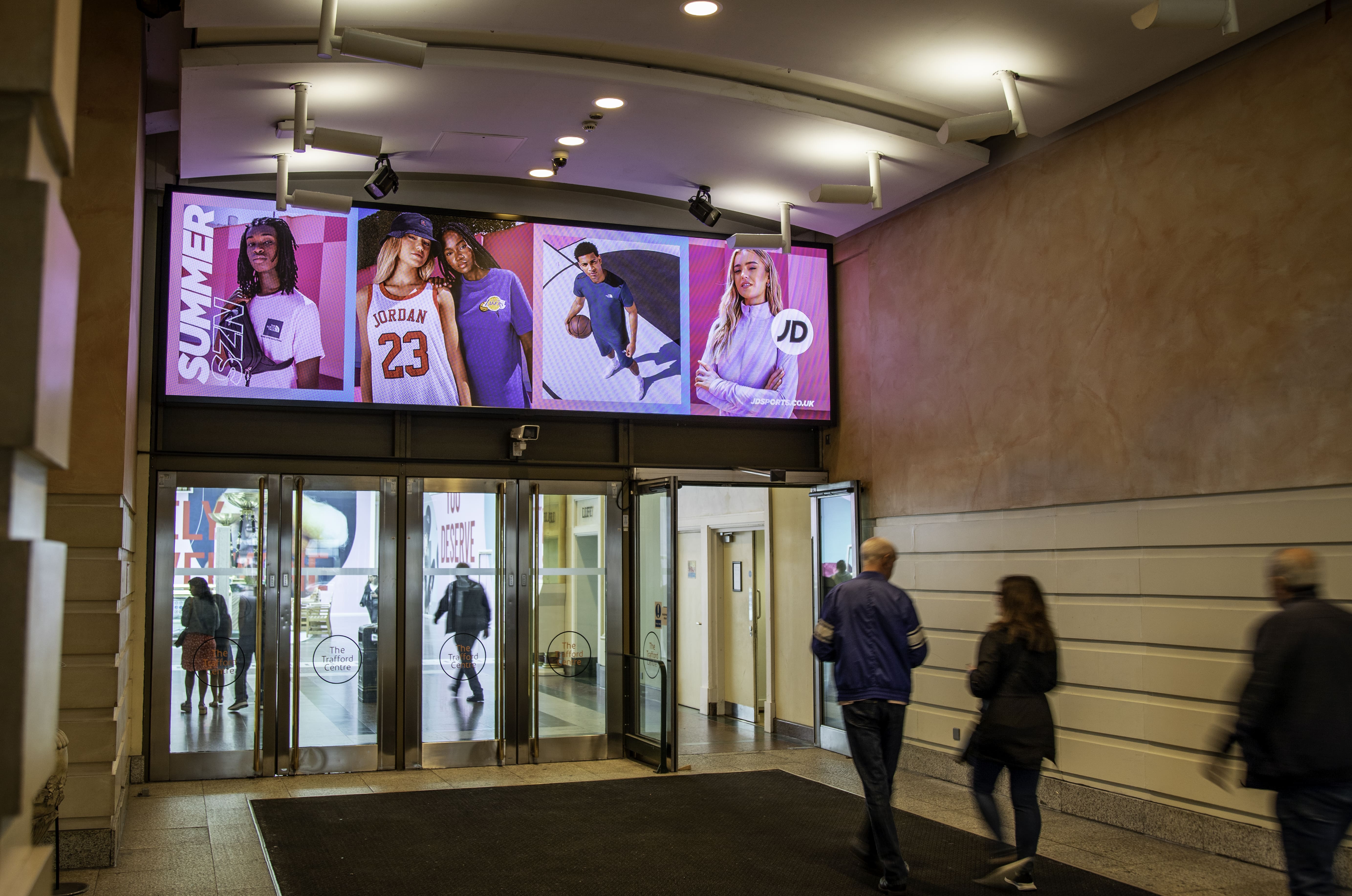 A digital horizontal billboard above the entrance and exit to the shopping centre