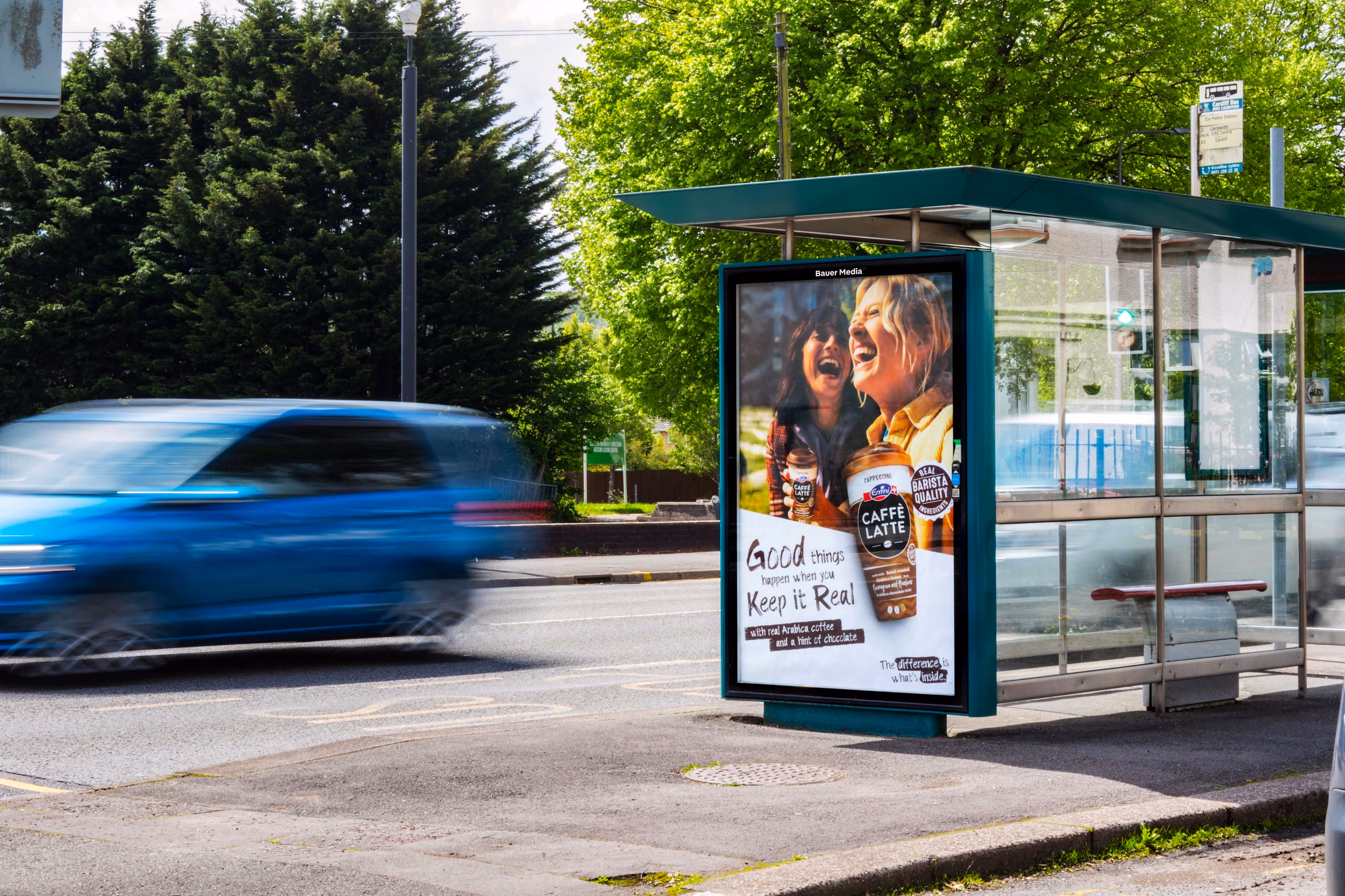 Emmi's caffe latte Adshel advertisement with two friends enjoying their barista quality coffee