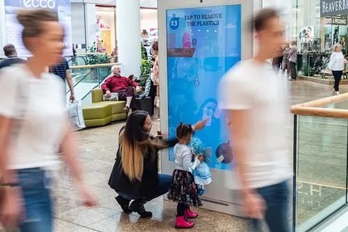 A family play on an interactive digital screen in a shopping mall