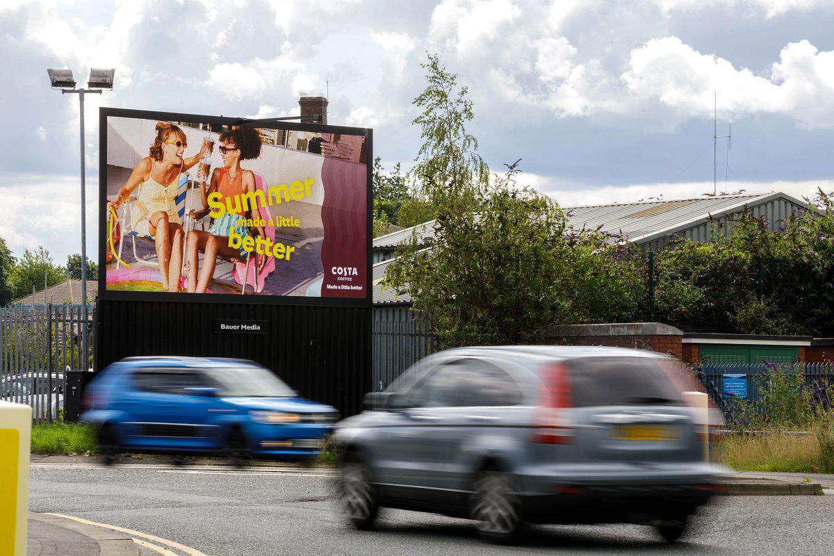 Costa advertising on a roadside digital billboard with cars driving by