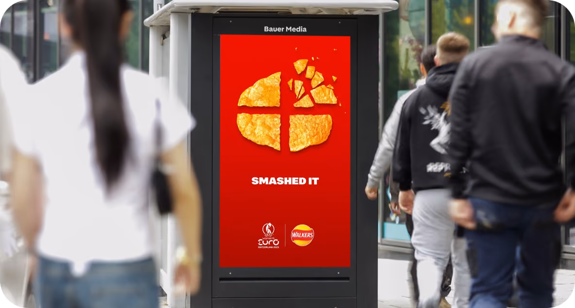Bus stop ad with a red background showing broken crisps arranged like a smashed pie chart above bold text 'SMASHED IT' and logos for Women's Euro Switzerland 2025 and Walkers.
