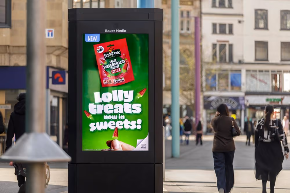 Outdoor digital ad for Rowntree's sour watermelon lollies with text 'Lolly treats now in sweets!'
