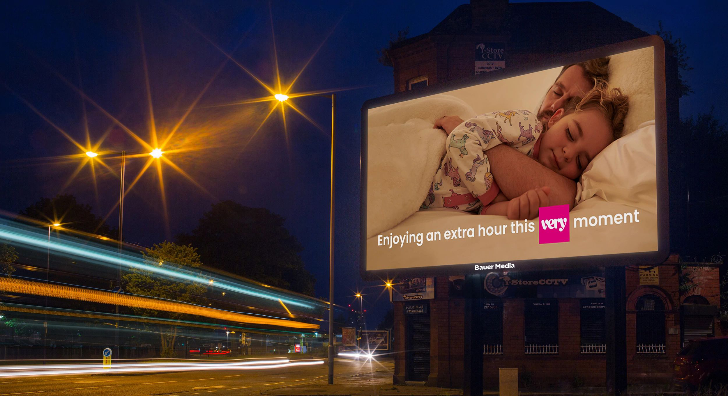 A Very ad campaign on a billboard with traffic going by in the evening