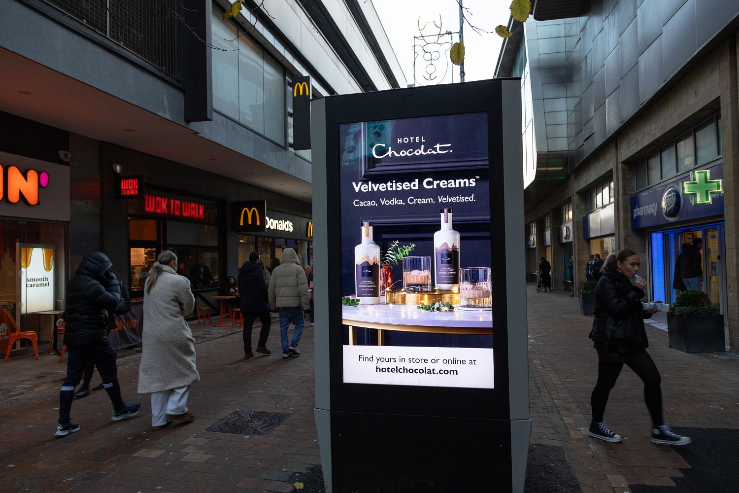 Hotel chocolate advertising on digital screen outside McDonalds and Boots