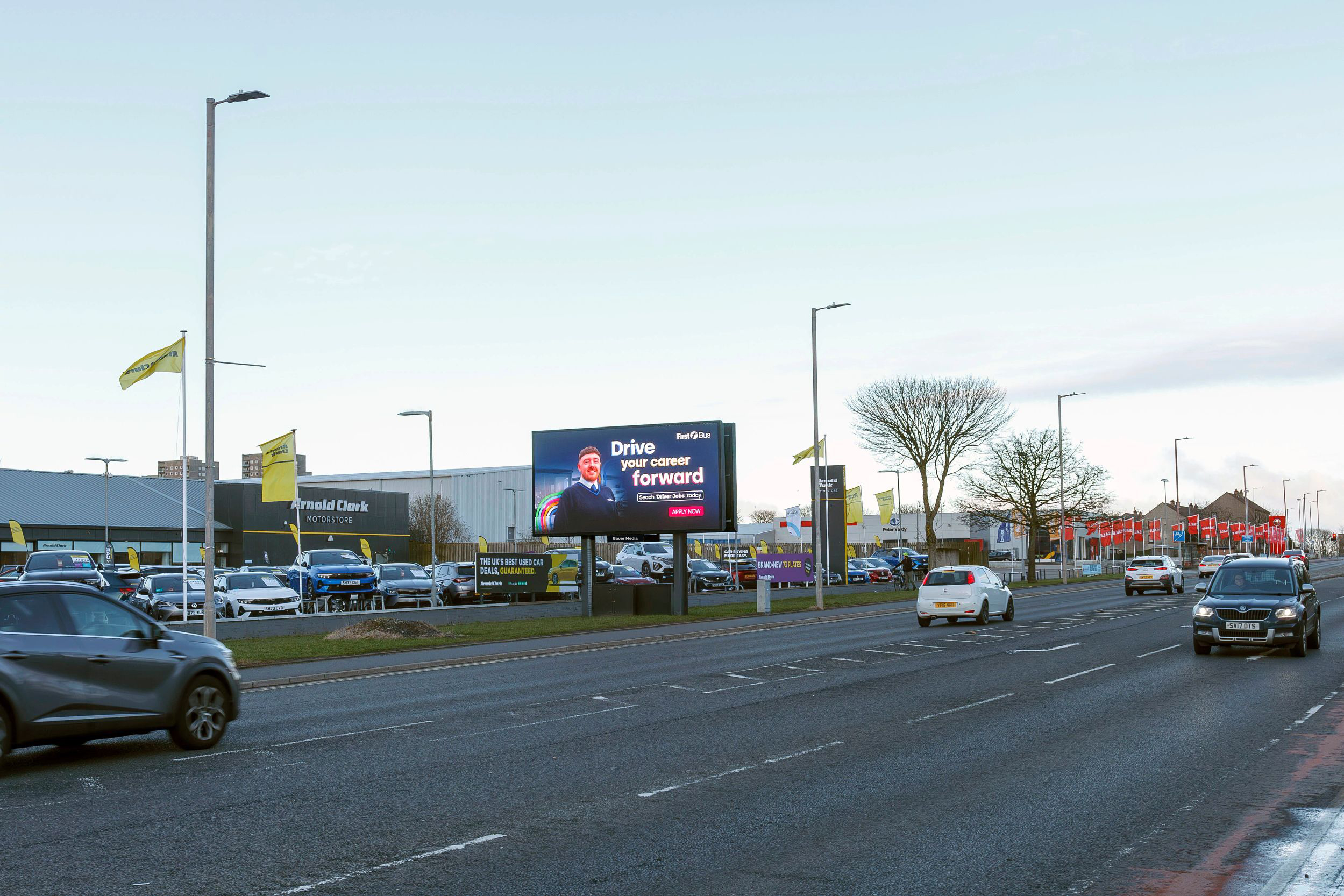 A digital billboard next to a busy road outside of an Arnold Clark