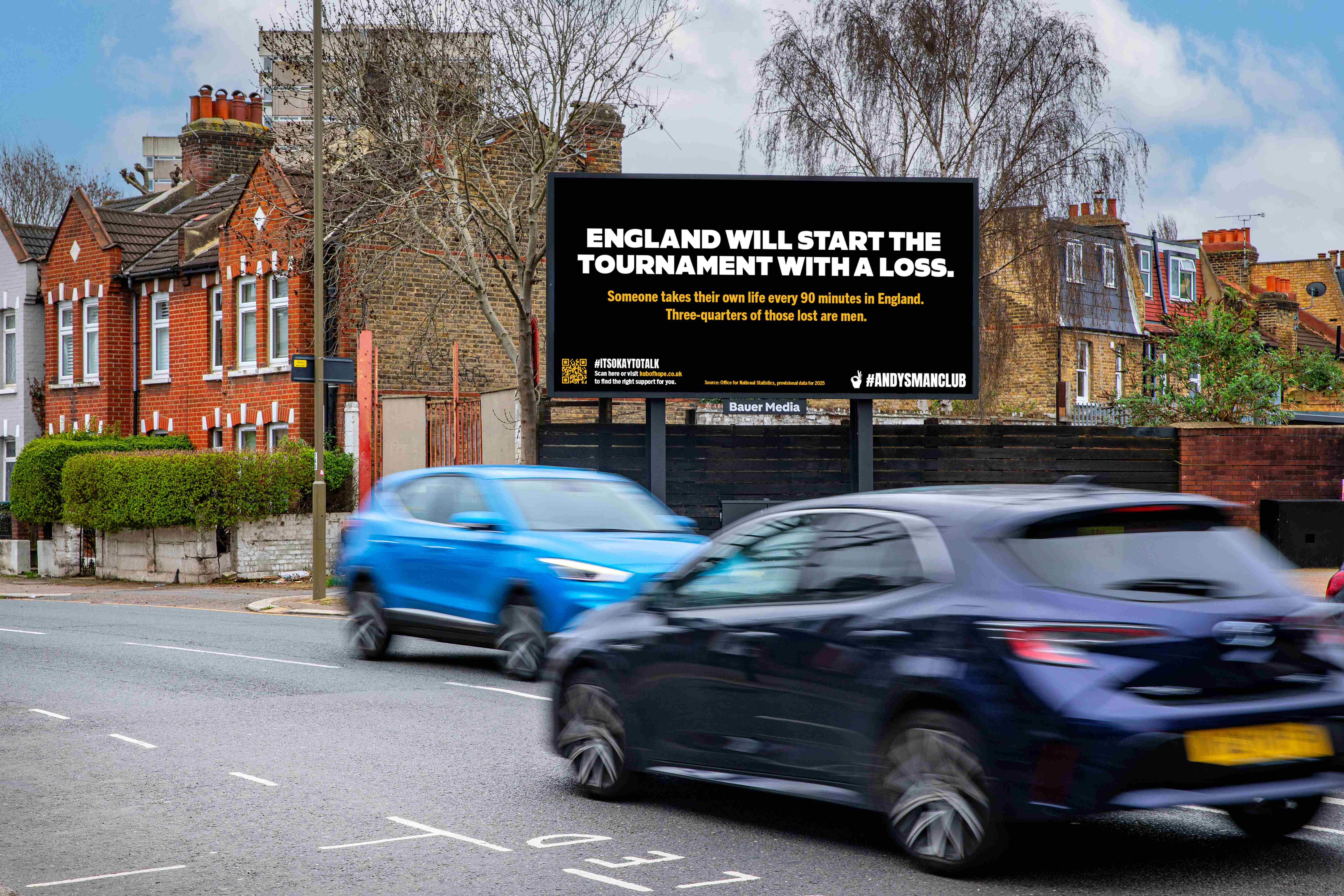 Bauer Media Outdoor billboard featuring an ANDYSMANCLUB advert, by a busy road as vehicles pass by during the day.