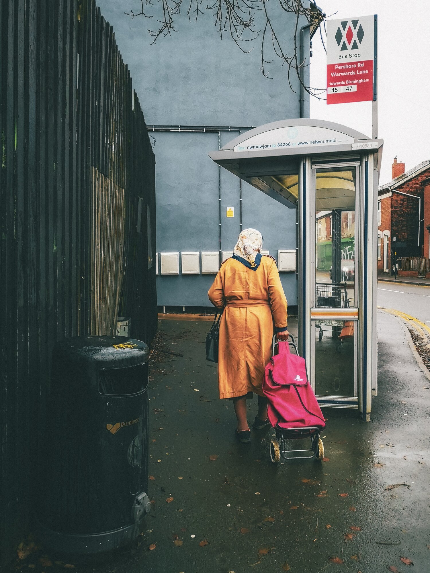A woman walking to a bus shelter