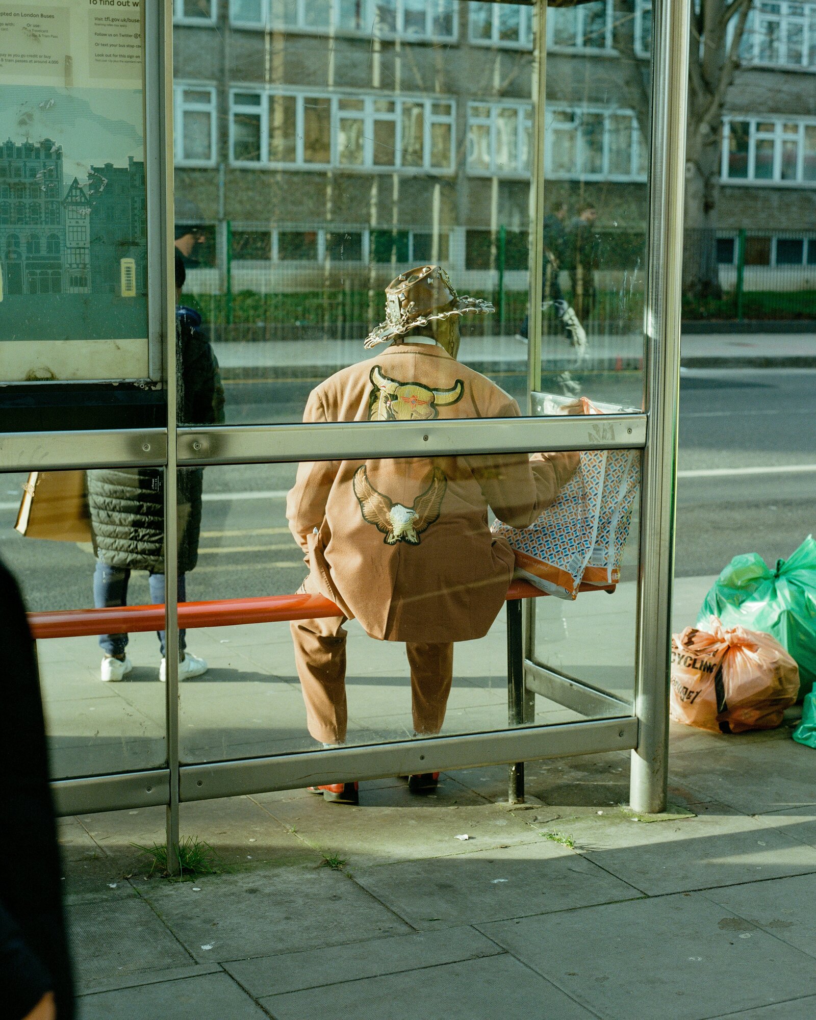 Man in cowboy hat waiting for bus at the bus stop