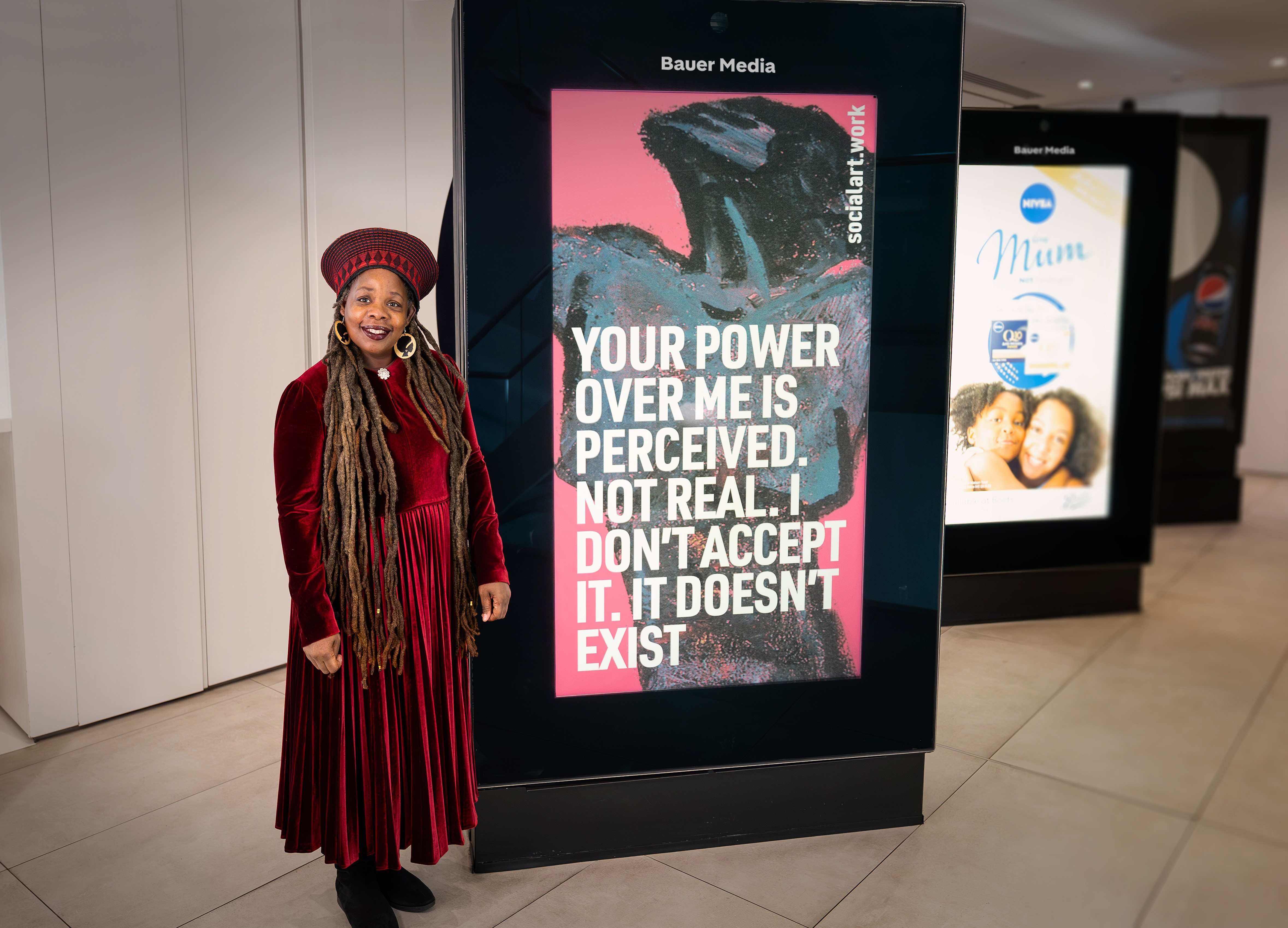 Ngozi Fulani standing next to an adshel sign.