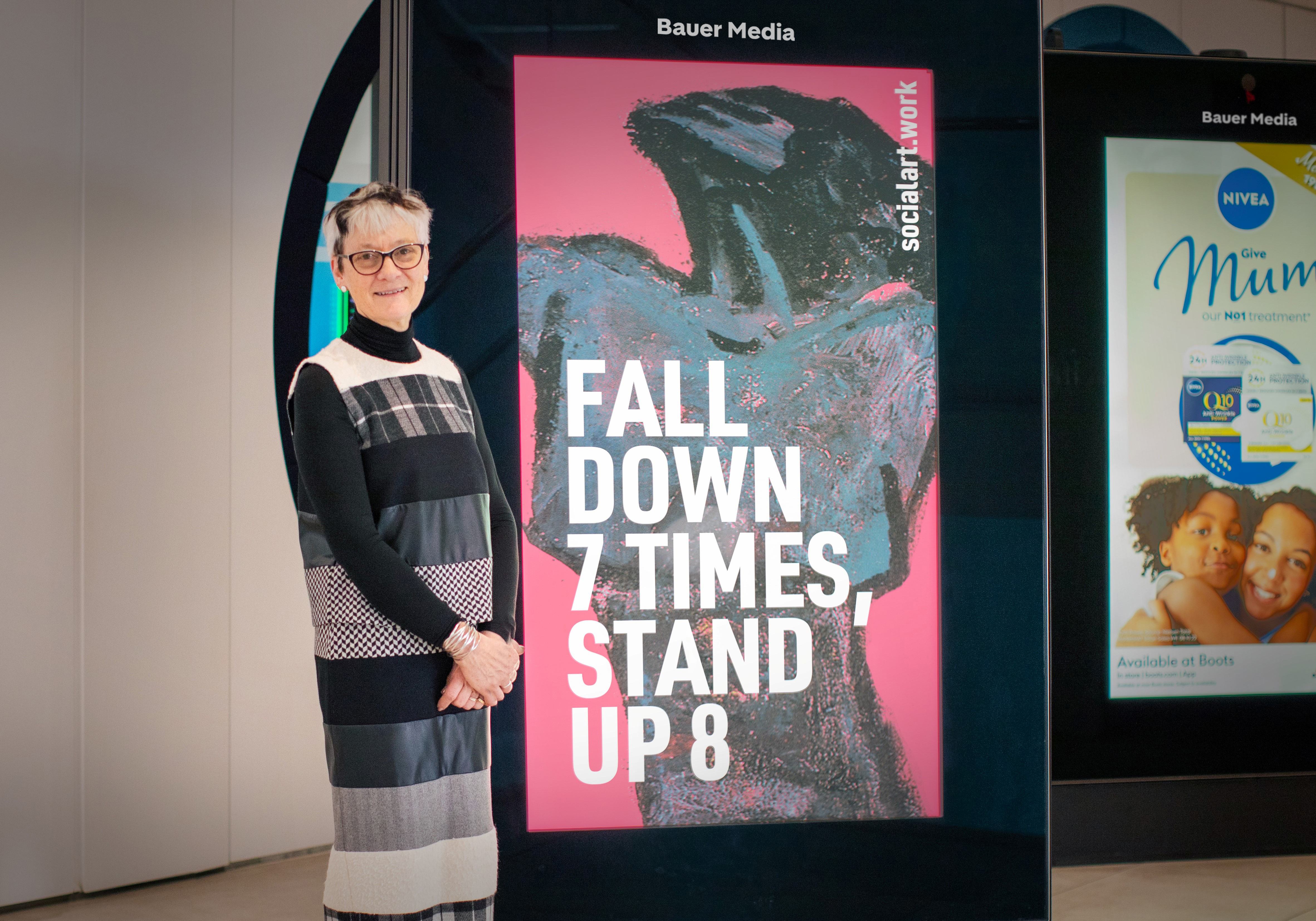 Rebecca Salter, President Royal Academy of Arts, stands in front of a digital screen displaying her quote and artwork by Martin Firrell, at Bauer Media Outdoor's HQ in London