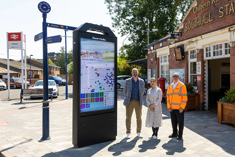 A Bauer Media Outdoor UK representative and members of Solihull Council alongside a new wayfinder unit, installed outside Solihull Station, during the day.