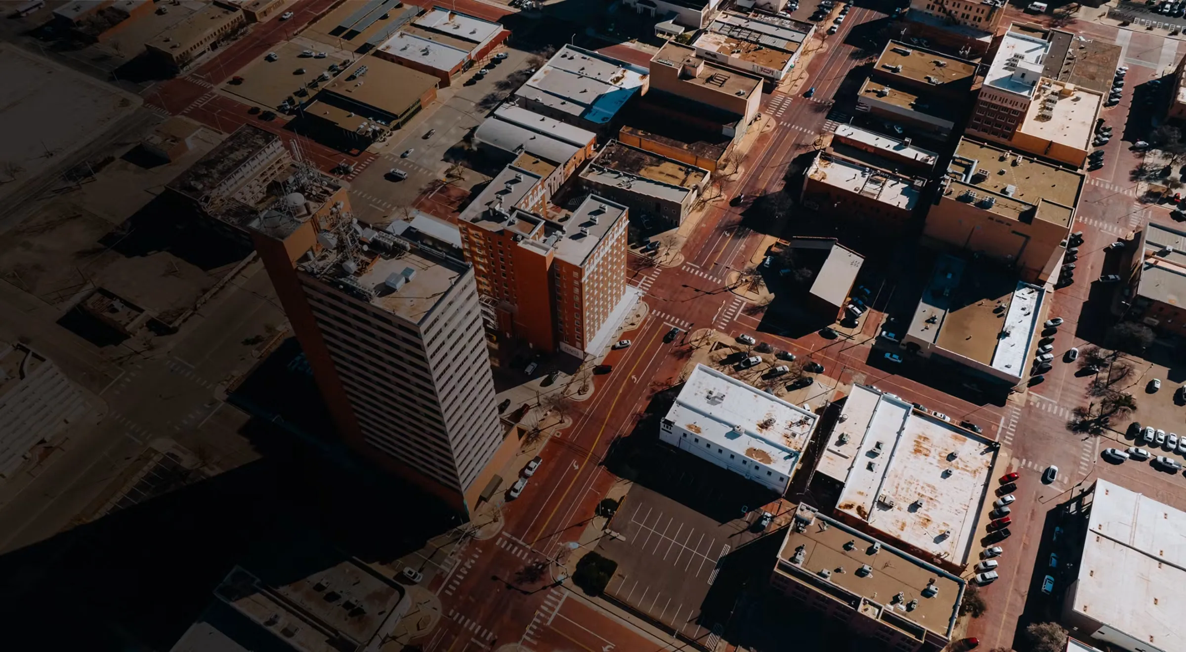 Aerial view of a downtown business district with office buildings, streets, and parking lots.