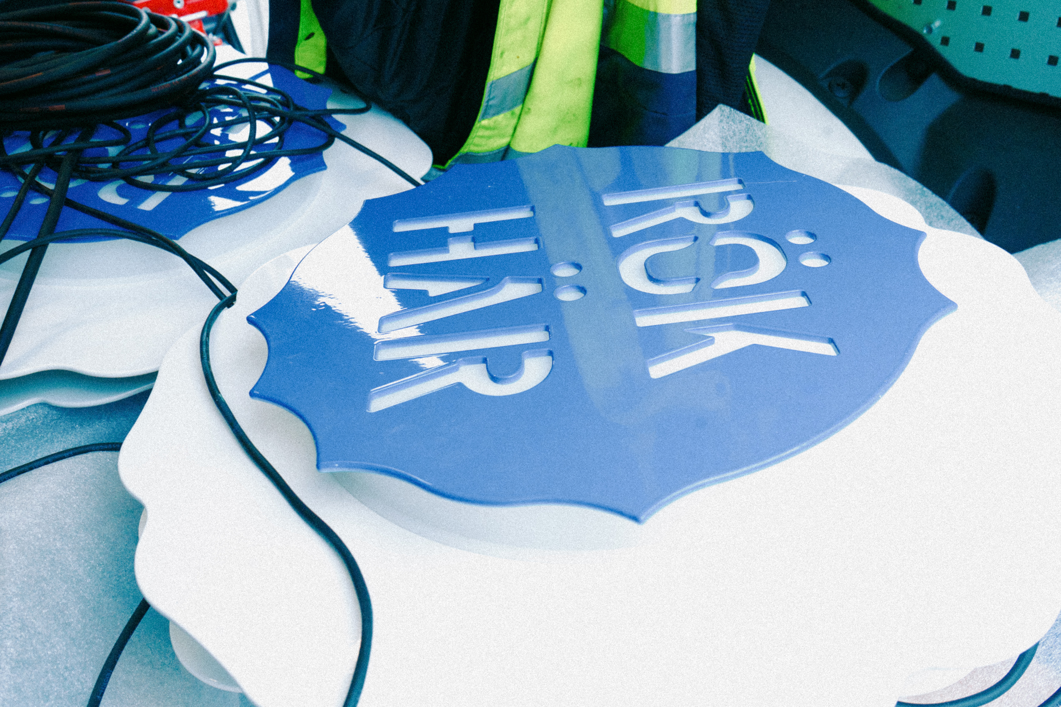 Stack of square blue and white coasters with 'Följ rökringen till rökningen' on a blue background and a smoke ring in the center.