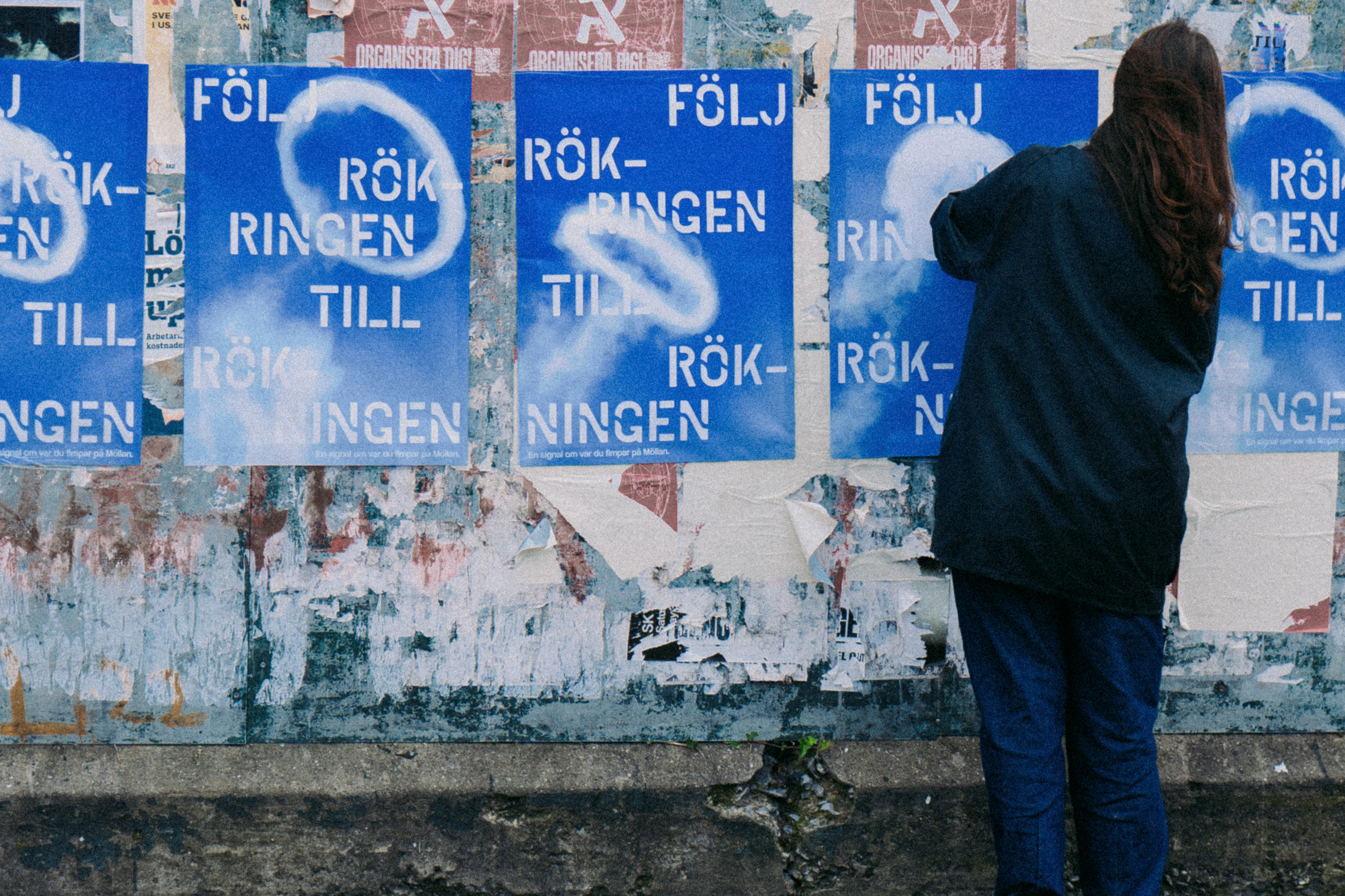 Stack of square blue and white coasters with 'Följ rökringen till rökningen' on a blue background and a smoke ring in the center.