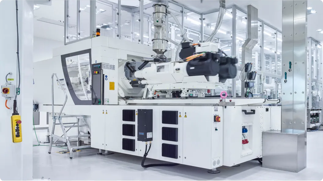 Weißes, modernes Spritzgussgerät in einer sauberen, hellen industriellen Produktionsumgebung.