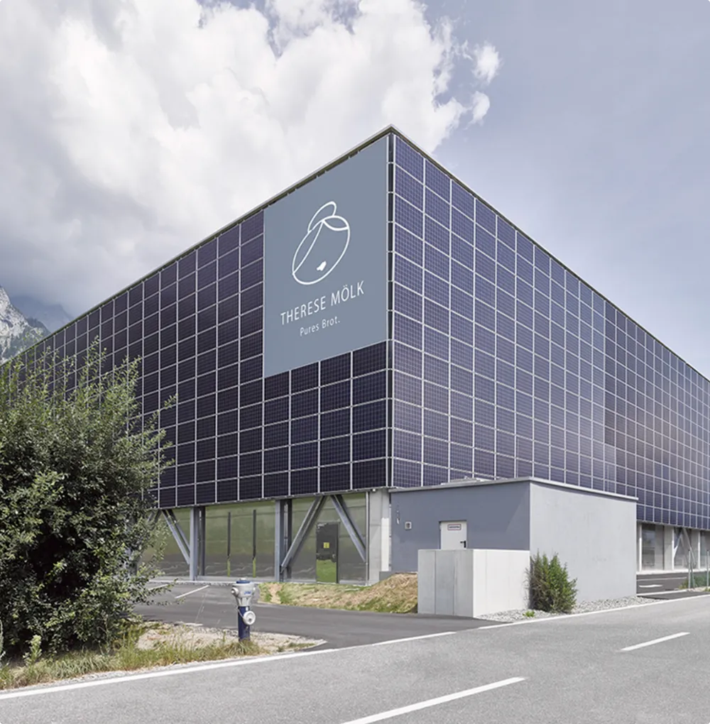 Modern industrial building with full-scale solar façade system as a sustainable energy source for climate-friendly corporate infrastructure.