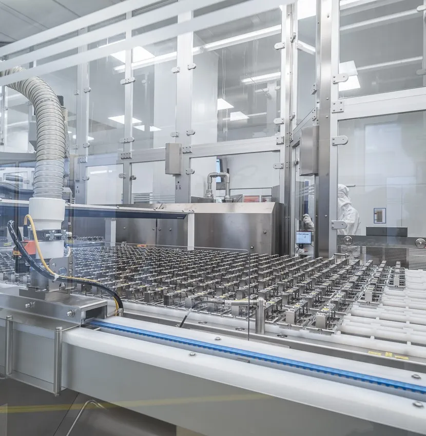 Automatisierte Produktionslinie in einer Industrieanlage mit Förderband und präziser Fertigungstechnologie.