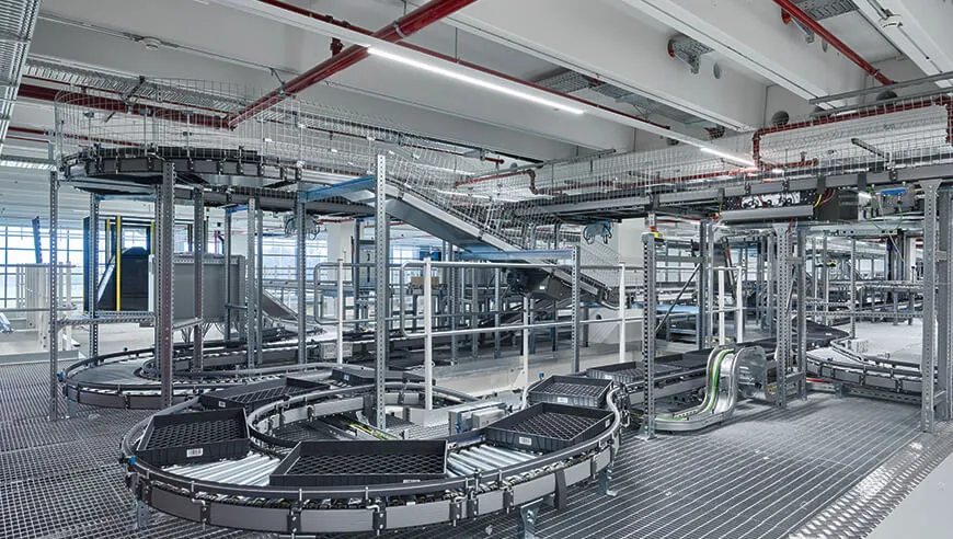 Eine moderne Industriehalle mit automatisierten Förderanlagen und komplexen Transportsystemen für effiziente und hygienische Lebensmittelverarbeitung.