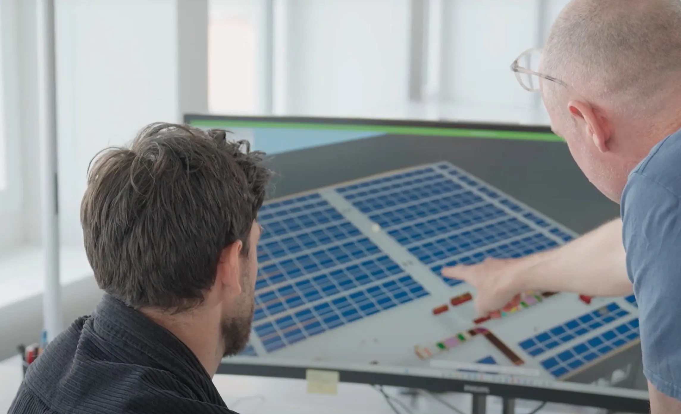 Zwei Personen betrachten einen Plan  und besprechen gemeinsam die Anordnung der Solaranlagen.