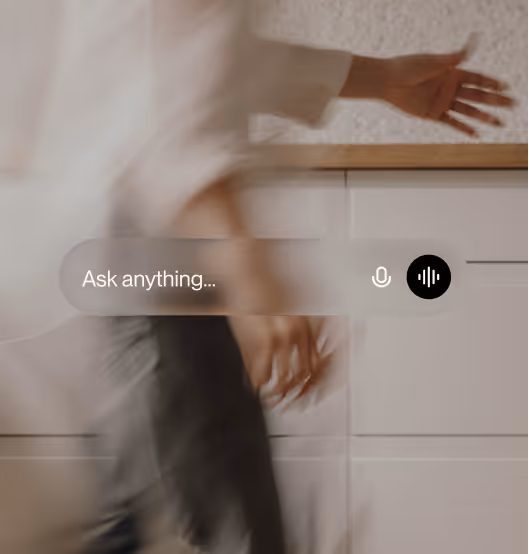 Blurred image of a person walking past a voice search bar with text 'Ask anything' and microphone icons.